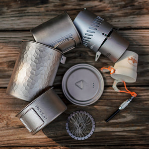 RidgeSong pot, mug, stove, bowl and lids arranged on a wooden surface.