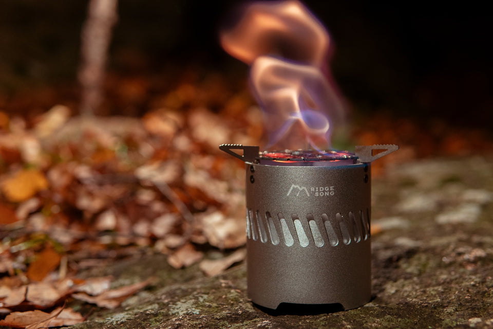 Blaze alcohol stove burning outdoors on a forest floor