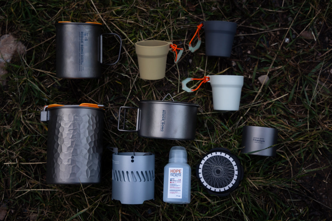 RidgeSong Mega Set cookware and brewing accessories laid out on grass outdoors